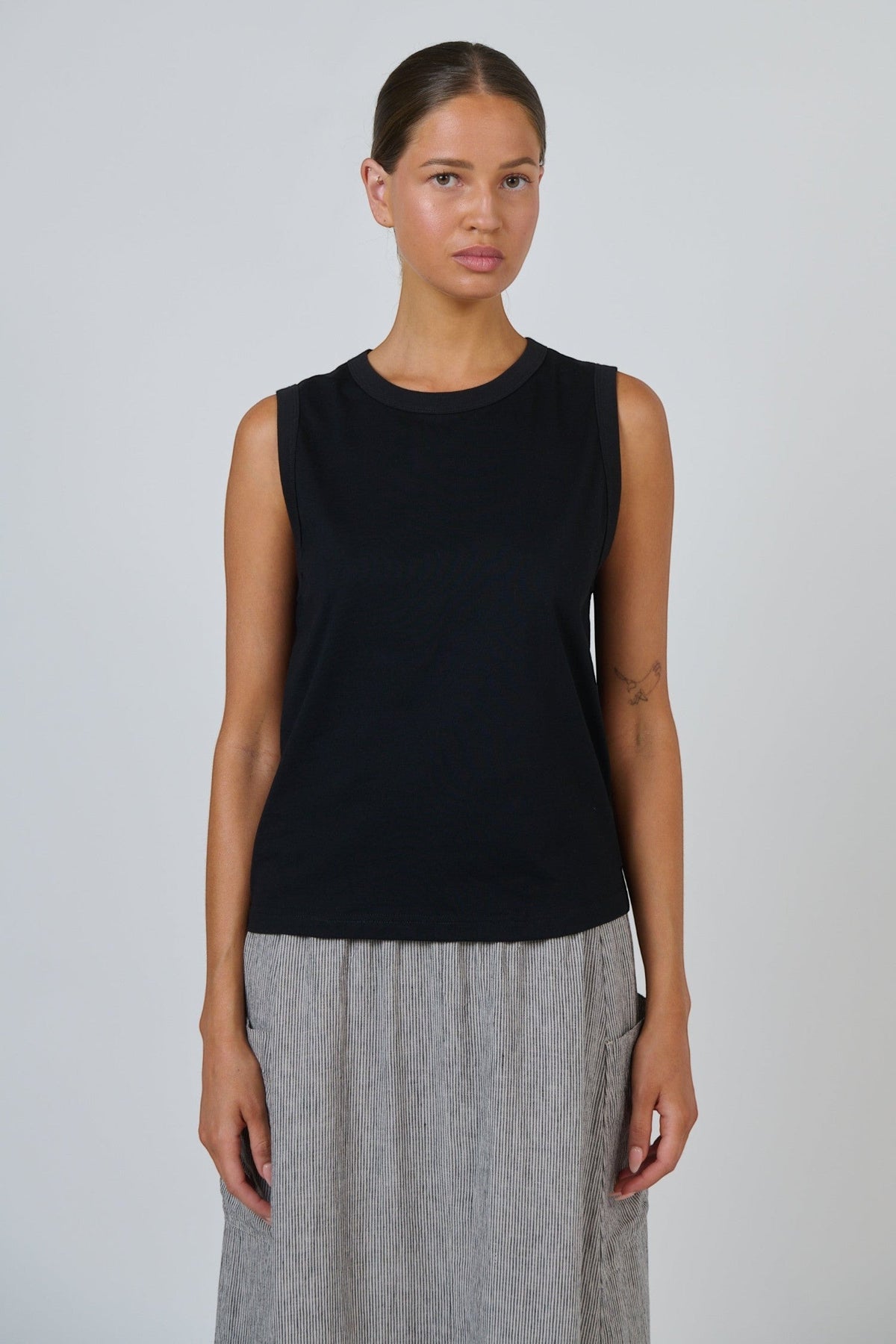ELSHAM BOUTIQUE black cotton sleeveless muscle top with a round neckline worn by a model against a white background