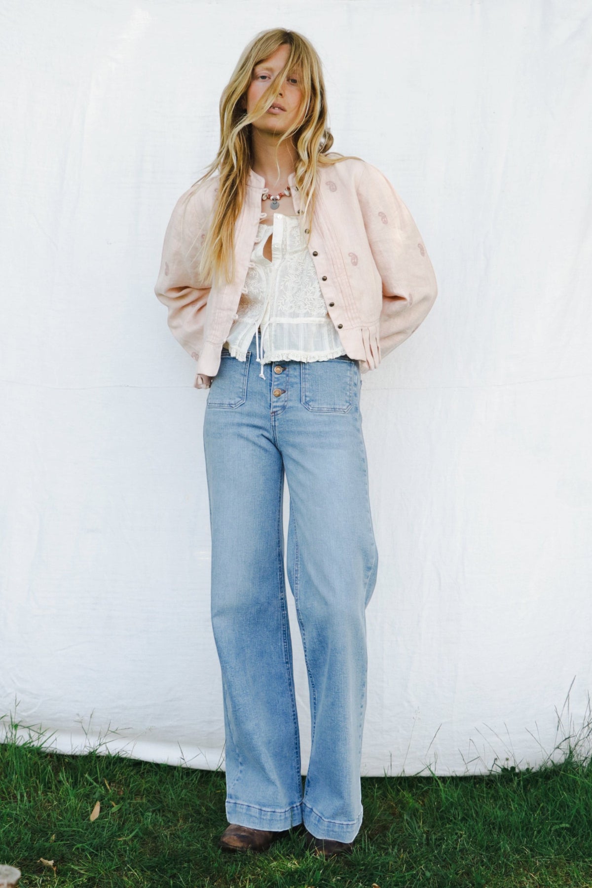 ELSHAM BOUTIQUE ivory cotton Constanza top with lace panel and drawstring waist worn with a light pink jacket and jeans