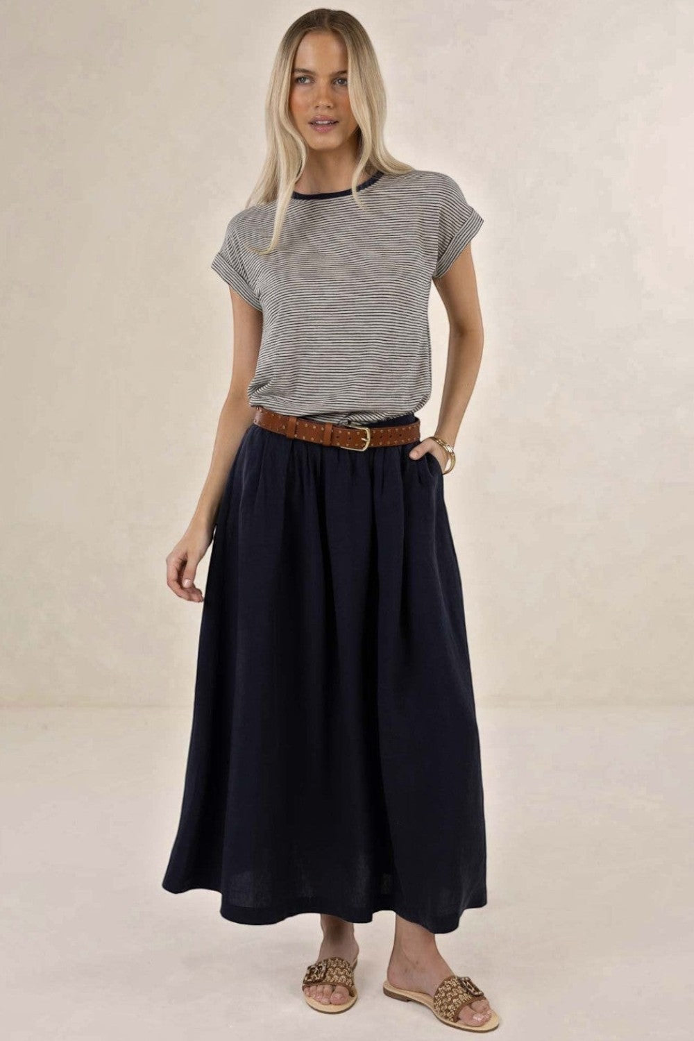 ELSHAM BOUTIQUE navy linen-tencel midi skirt with A-line silhouette and side pockets worn by a blonde model
