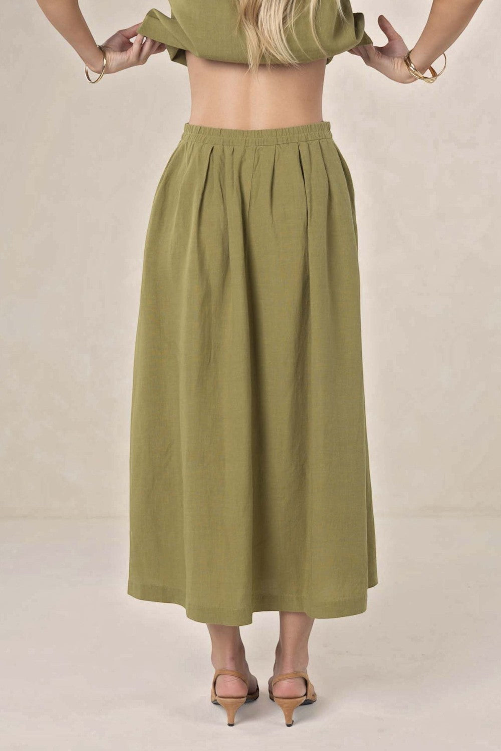ELSHAM BOUTIQUE olive green linen-tencel midi skirt with an A-line silhouette and elasticated waist, back view.