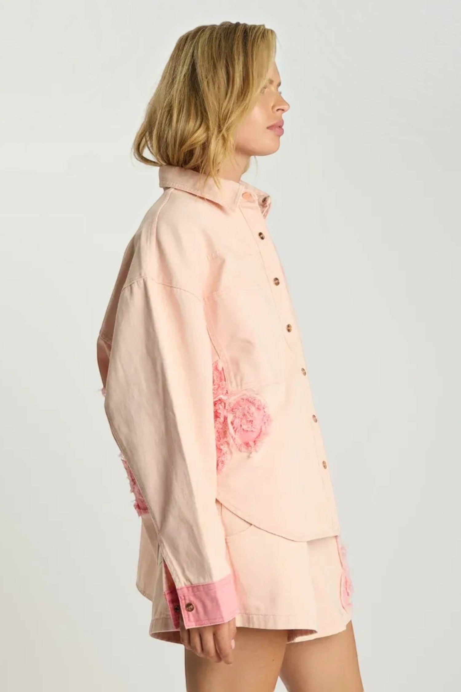 Model wearing ELSHAM BOUTIQUE pink petal oversized cotton denim shacket with frayed edges and button-through front