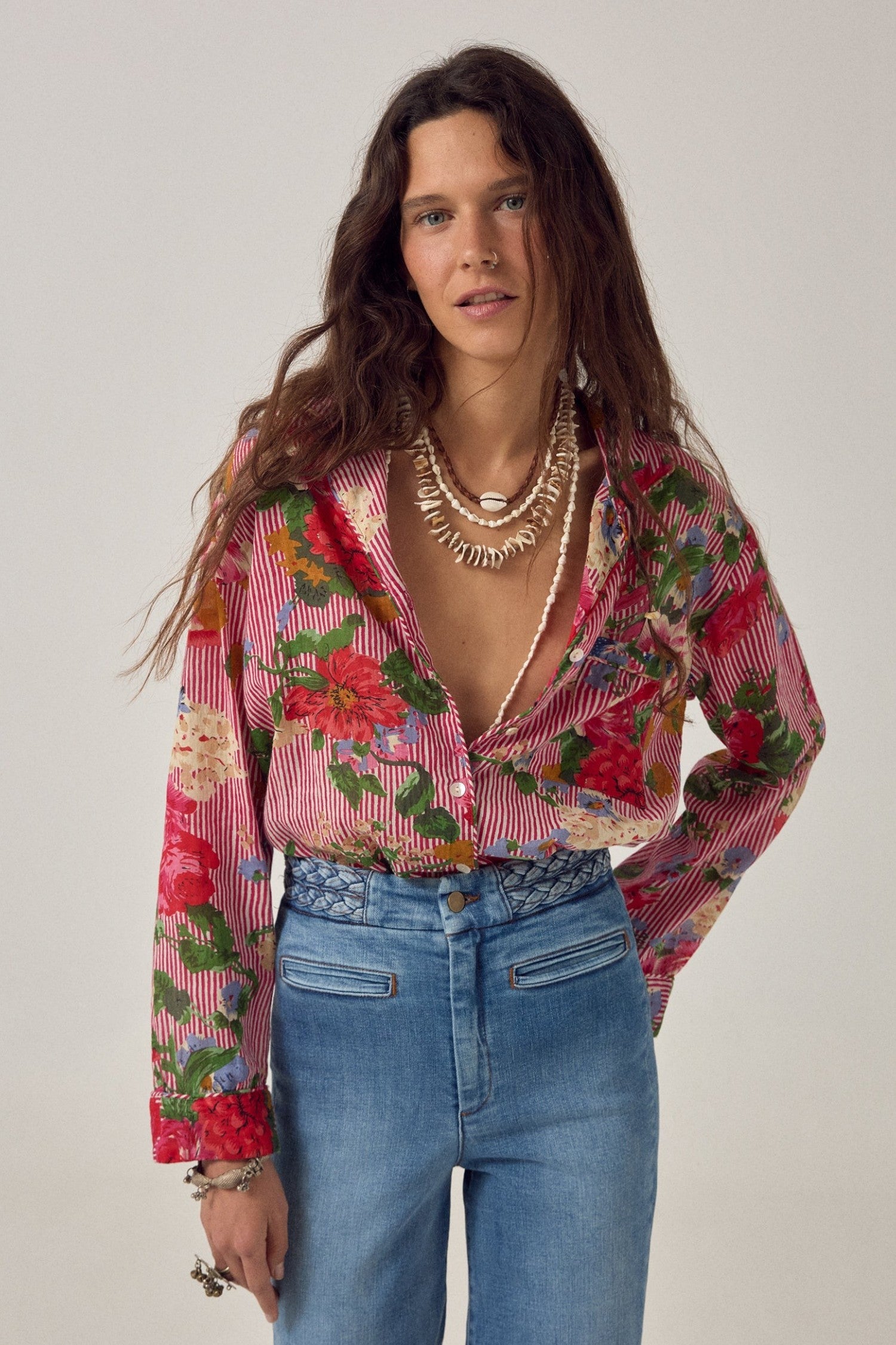 ELSHAM BOUTIQUE Piti shirt in rouge featuring a floral print over fine stripes, worn with blue jeans.