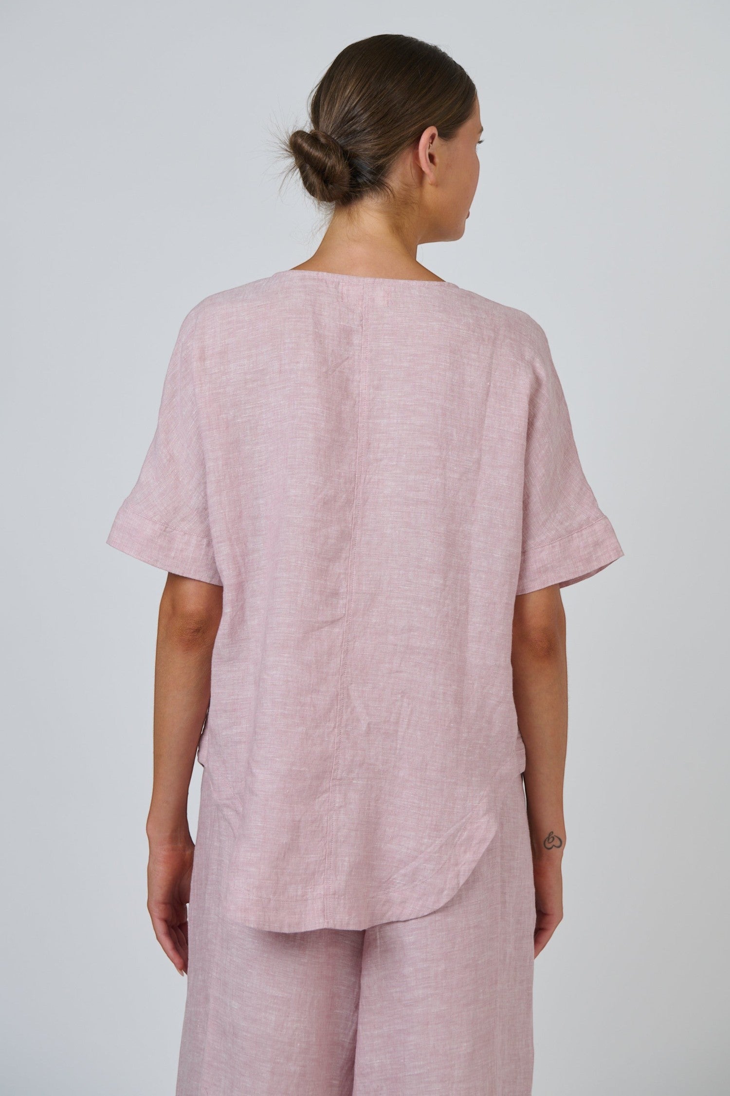 Back view of ELSHAM BOUTIQUE radish pink linen top with short sleeves and a relaxed oversized fit