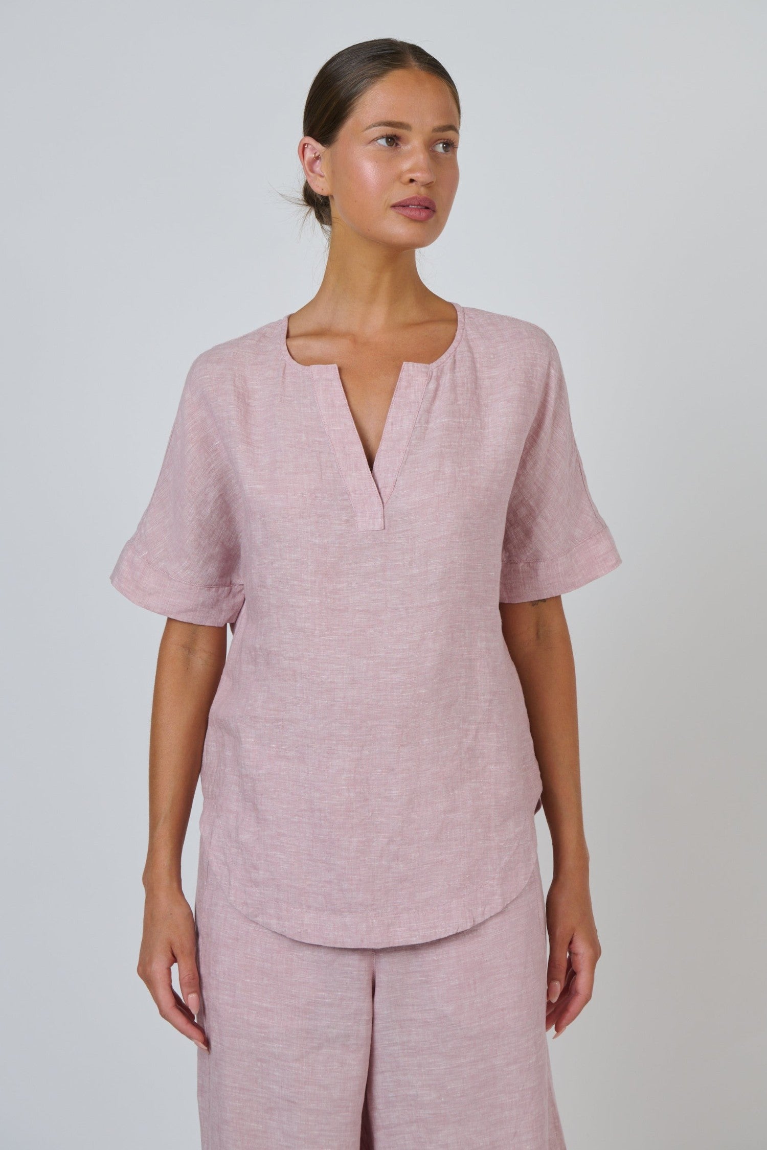 ELSHAM BOUTIQUE GA718 radish pink linen top with a split V-neckline and relaxed short sleeves on a model