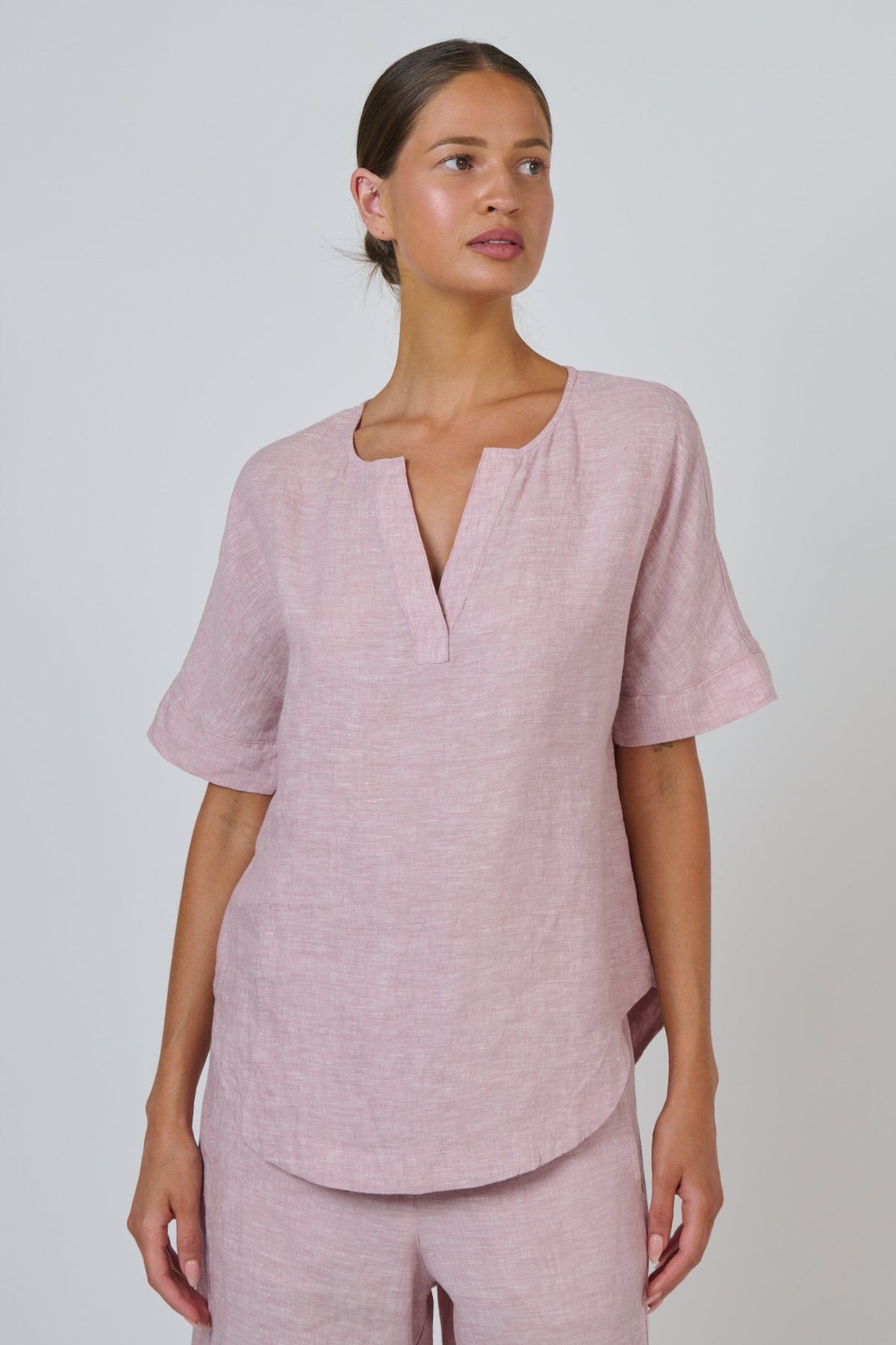 ELSHAM BOUTIQUE radish pink linen top with a split V-neckline and relaxed short sleeves on a model