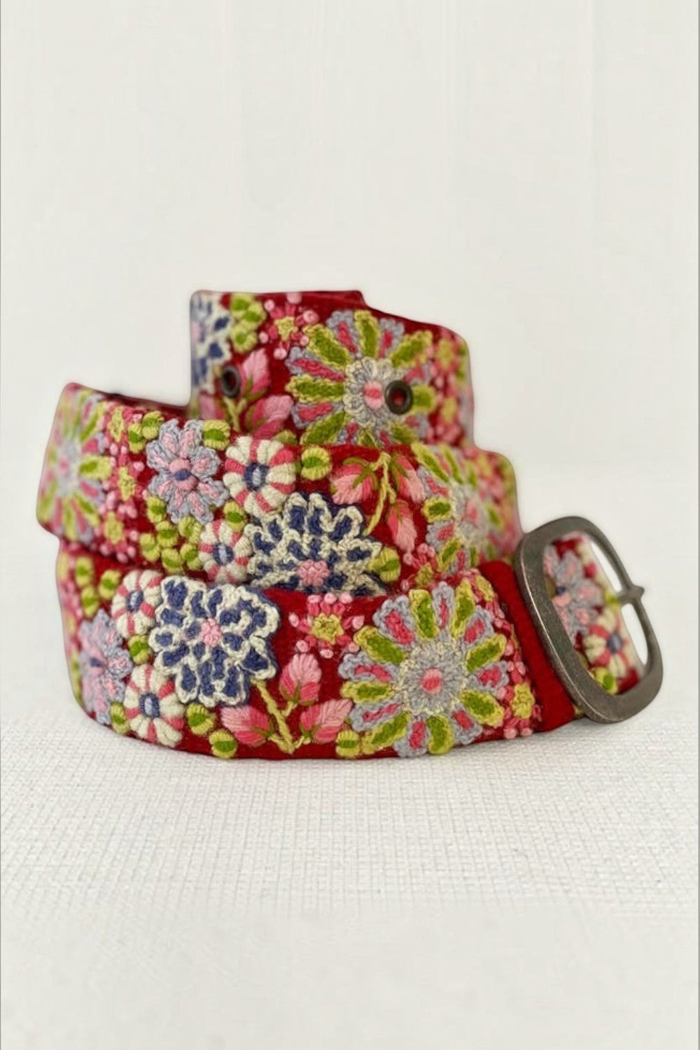 ELSHAM BOUTIQUE red wool belt featuring intricate multi-colored floral embroidery and a lead-free metal buckle.