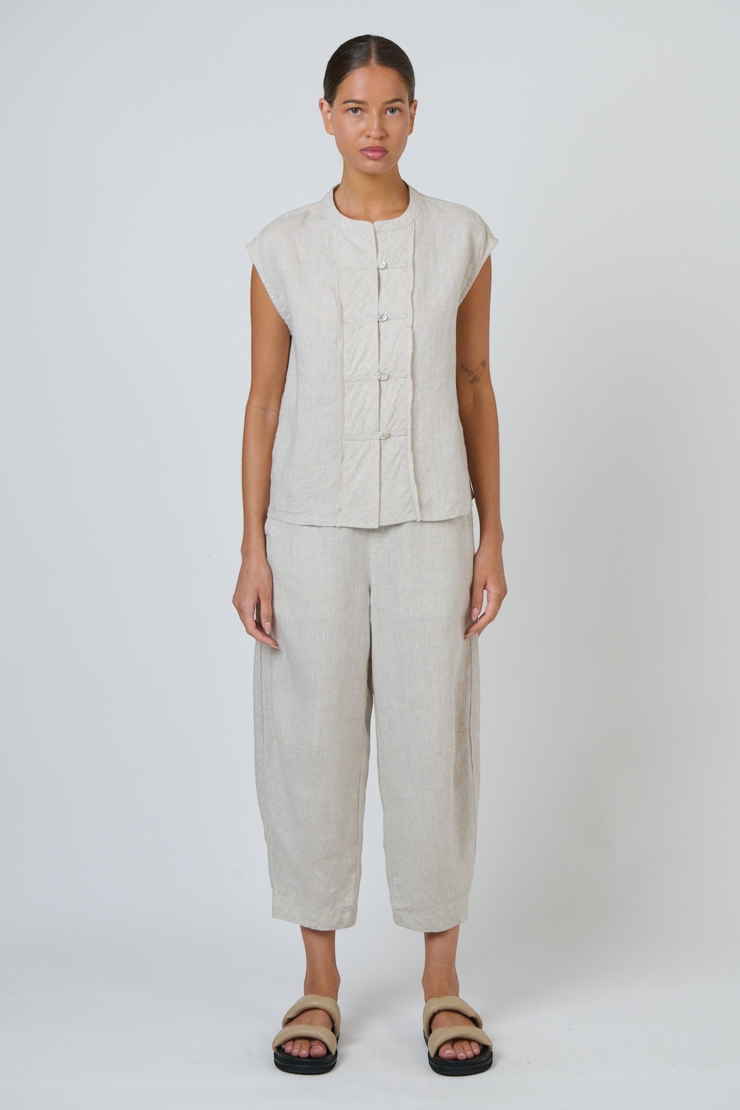 ELSHAM BOUTIQUE sand linen cropped tapered pants with an elasticated waistband and side pockets on a female model