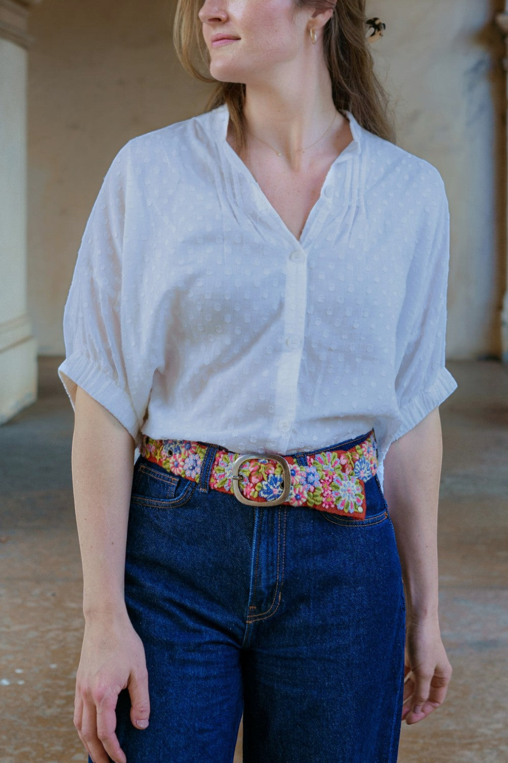 ELSHAM BOUTIQUE Teaberry wool belt with colorful floral embroidery and a metal buckle worn with jeans and a white top