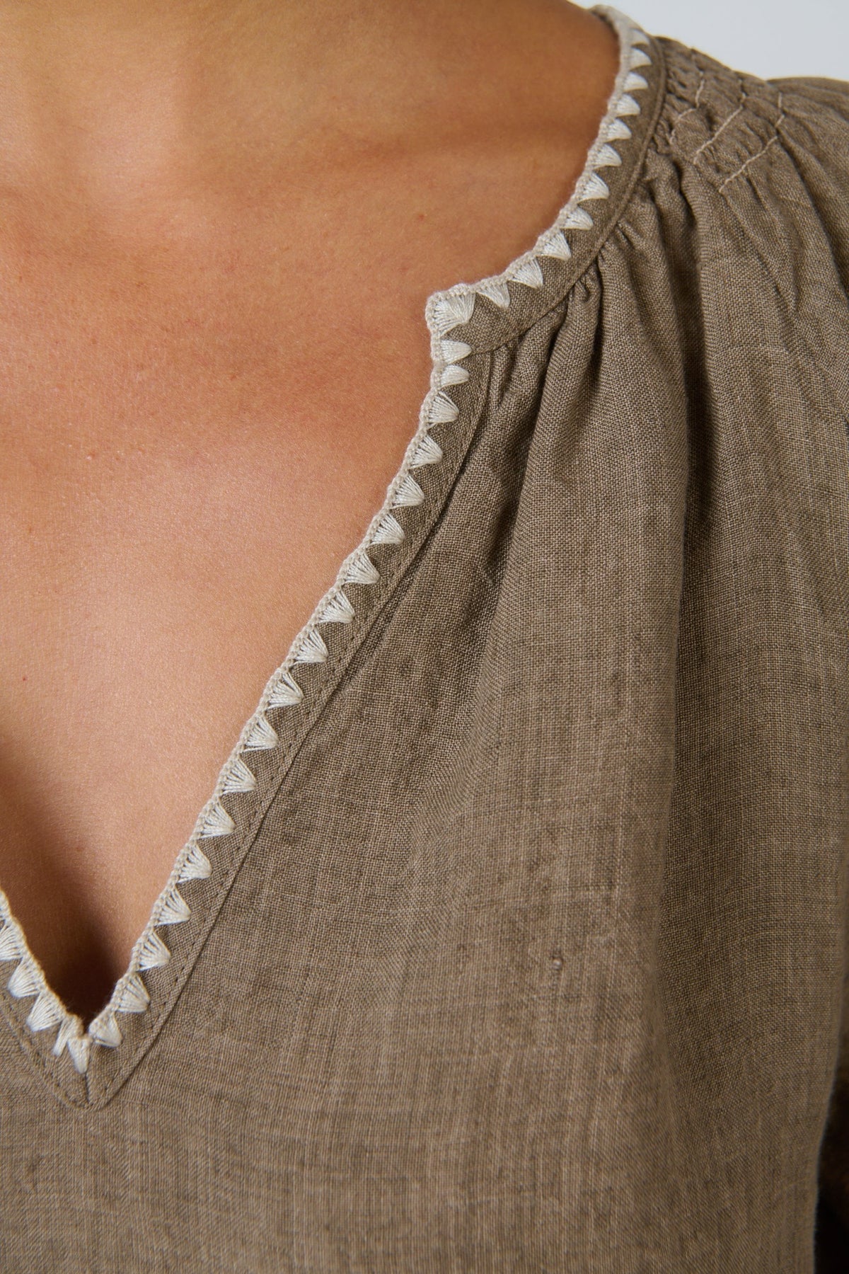 ELSHAM BOUTIQUE agate linen shift dress featuring a V-neckline with white contrast embroidery and gathered shoulders.