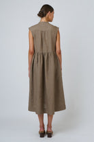 Back view of ELSHAM BOUTIQUE agate linen midi dress with drop waist, cap sleeves, and yoke detail on a model.
