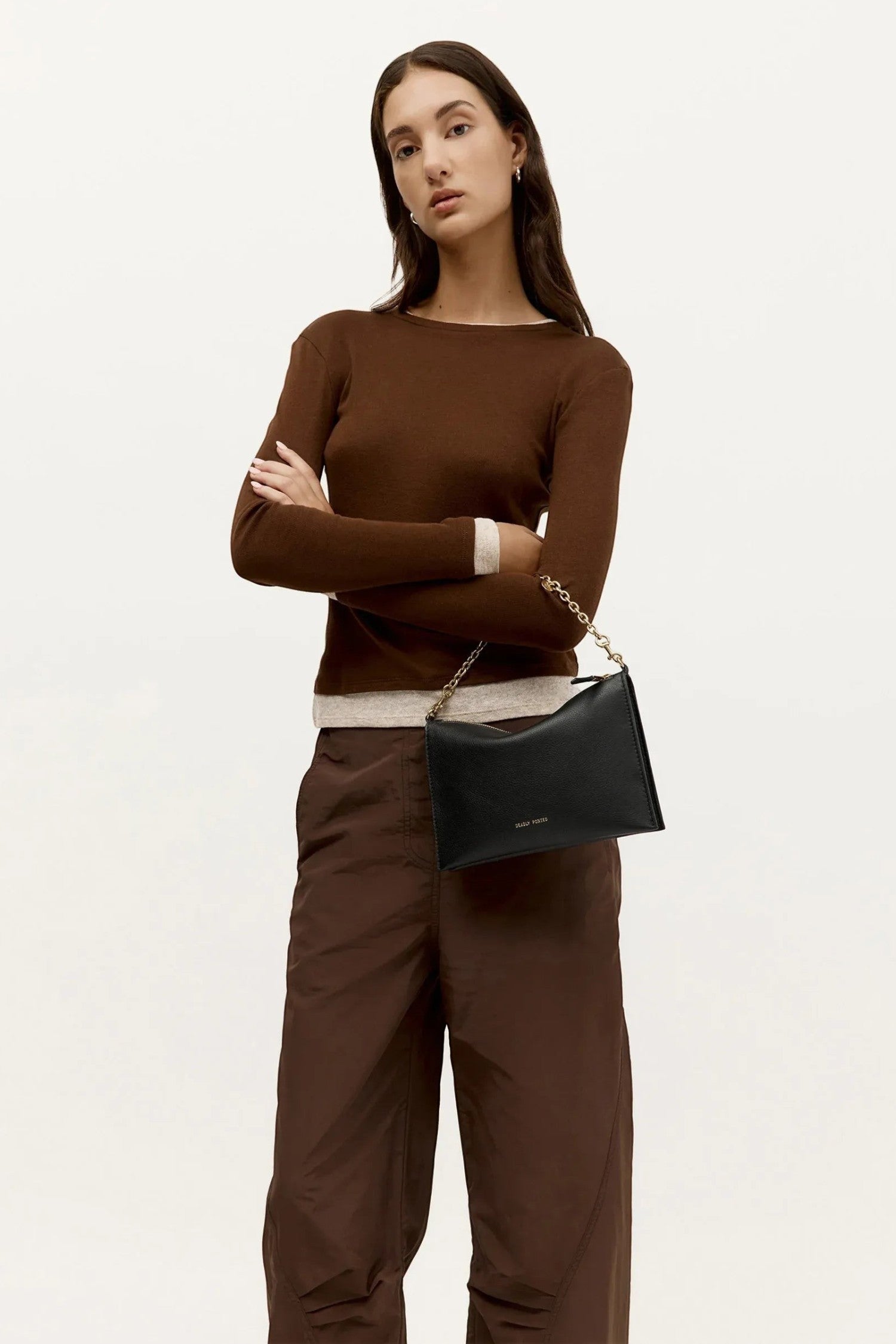 Model wearing ELSHAM BOUTIQUE black calf nappa Siamese bag with gold brass chain handle and adjustable strap