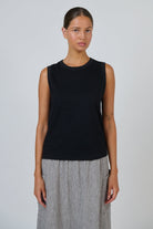ELSHAM BOUTIQUE black cotton sleeveless muscle top with a round neckline worn by a model against a white background