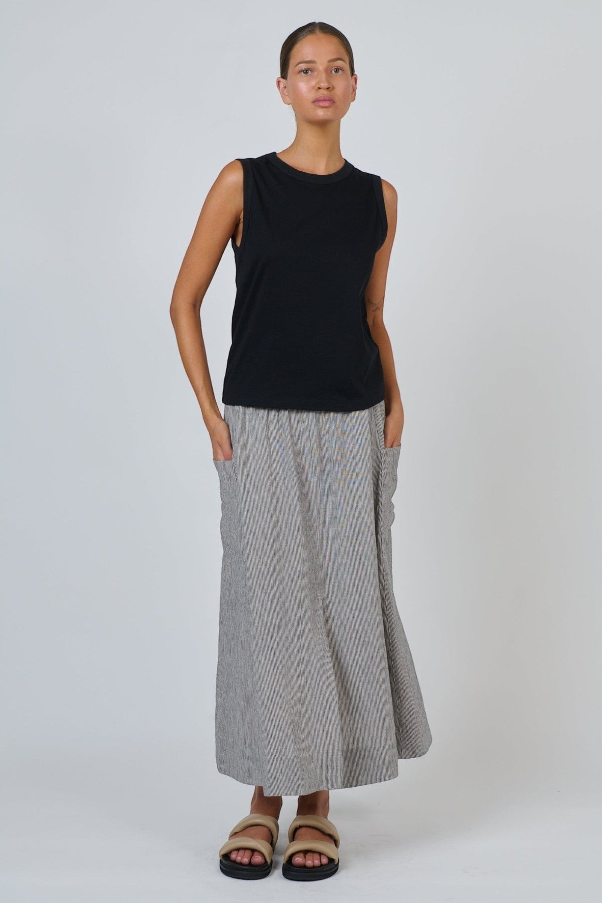 ELSHAM BOUTIQUE black cotton sleeveless muscle top with a round neckline worn by a model with a grey maxi skirt