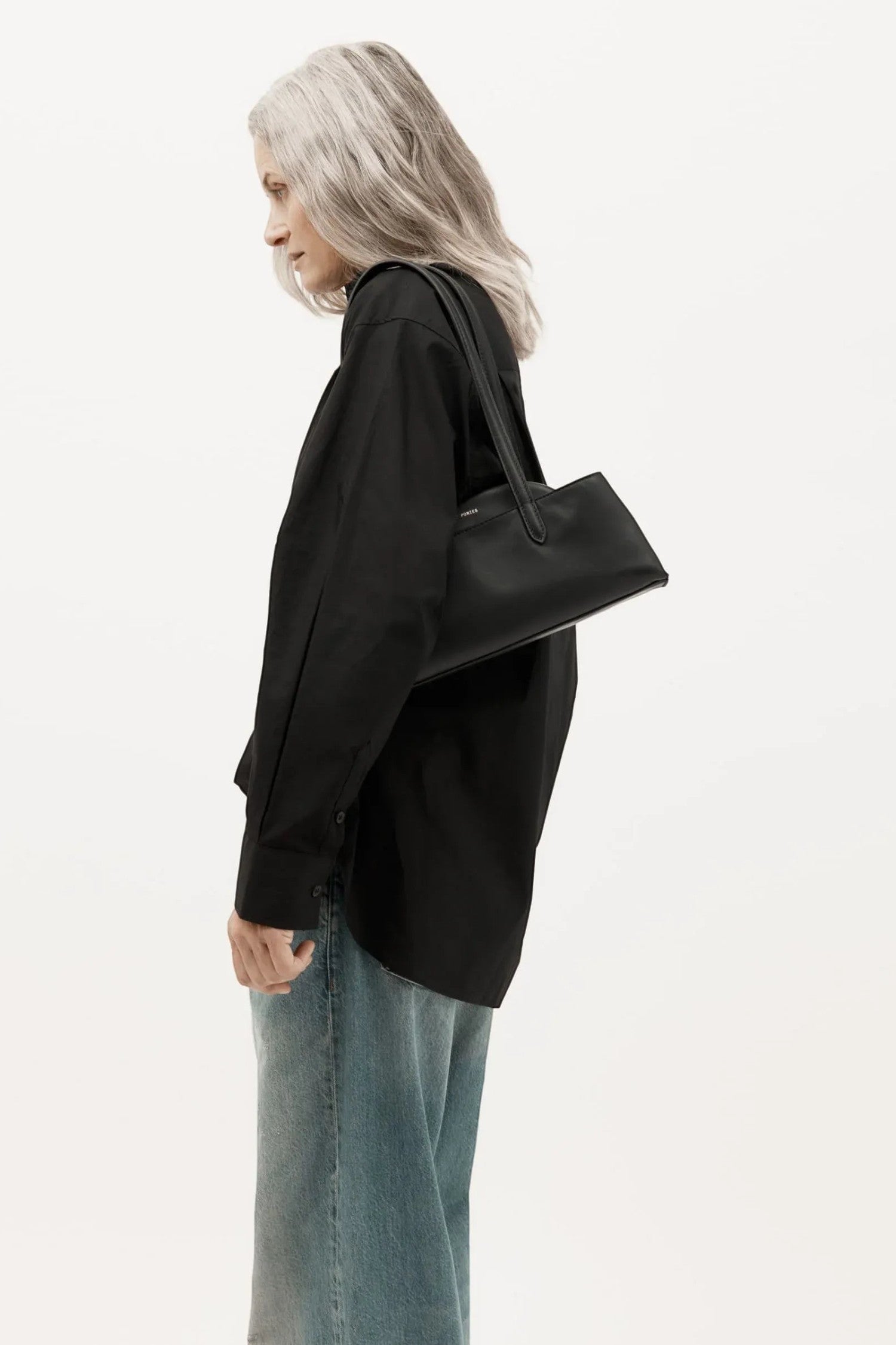 ELSHAM BOUTIQUE Mini Vault Tote in black ironed calf nappa leather with brass hardware, worn over the shoulder.