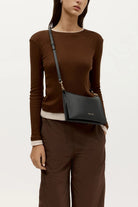 ELSHAM BOUTIQUE black calf nappa leather Siamese bag worn as a crossbody with gold hardware and adjustable strap