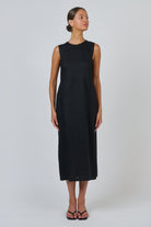 Model wearing an ELSHAM BOUTIQUE black sleeveless linen midi dress with a round neckline and fitted bodice