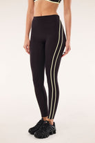 ELSHAM BOUTIQUE black bean high-rise leggings with soft yellow contrast flatlock side seams and side pockets.