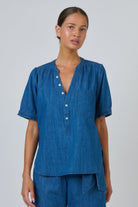 ELSHAM BOUTIQUE chambray linen blouse with V-neck, button placket, and puffed short sleeves on a model