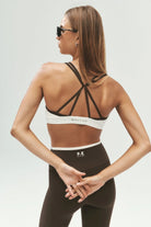 ELSHAM BOUTIQUE model wearing coffee and whisper white P.E Nation sports bra and high-rise leggings from behind