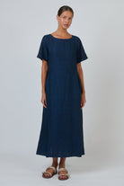Model wearing ELSHAM BOUTIQUE eclipse blue 100% linen midi dress with scoop neckline and short sleeves.