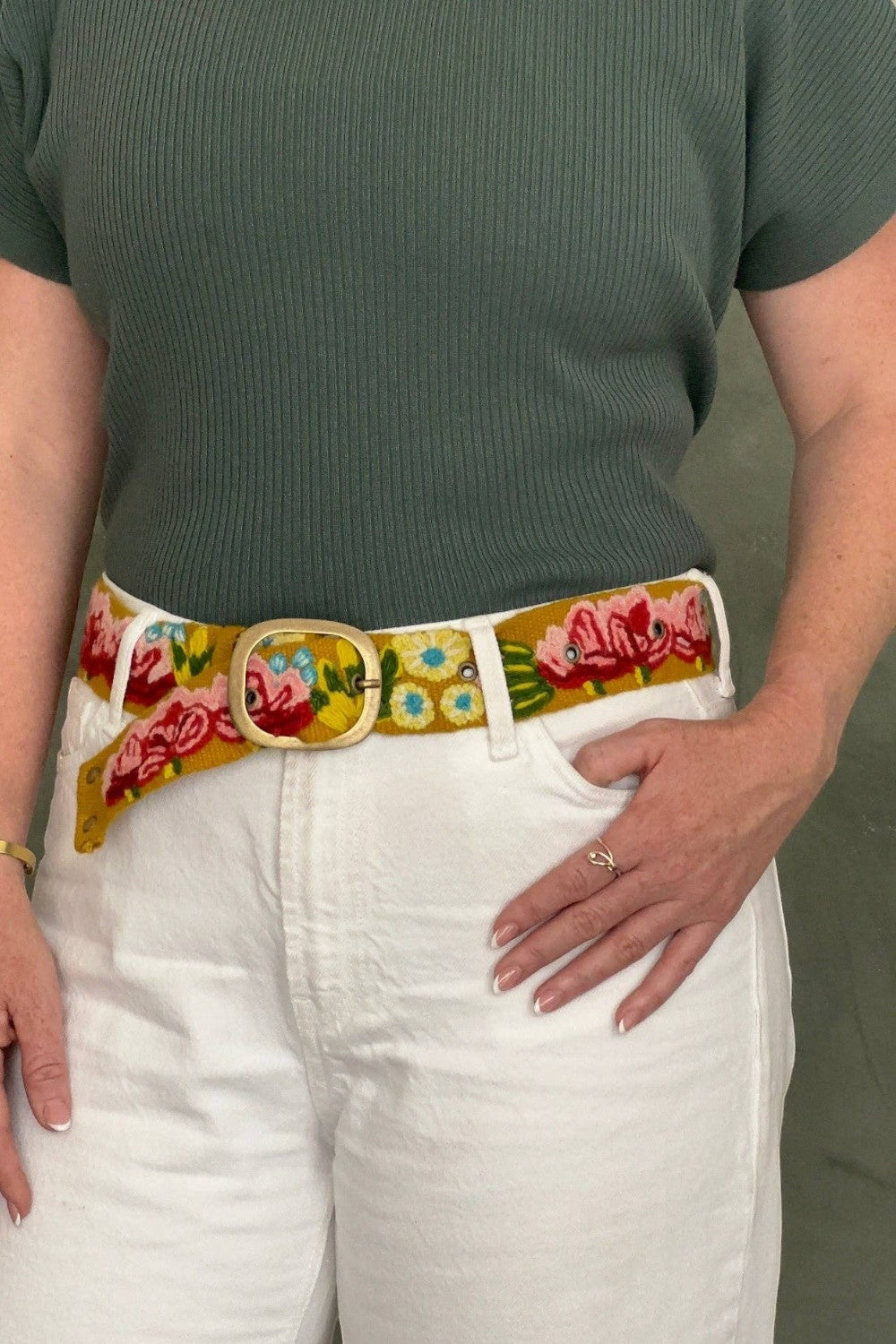 ELSHAM BOUTIQUE Giverny embroidered wool belt with floral pattern and metal buckle worn over white jeans