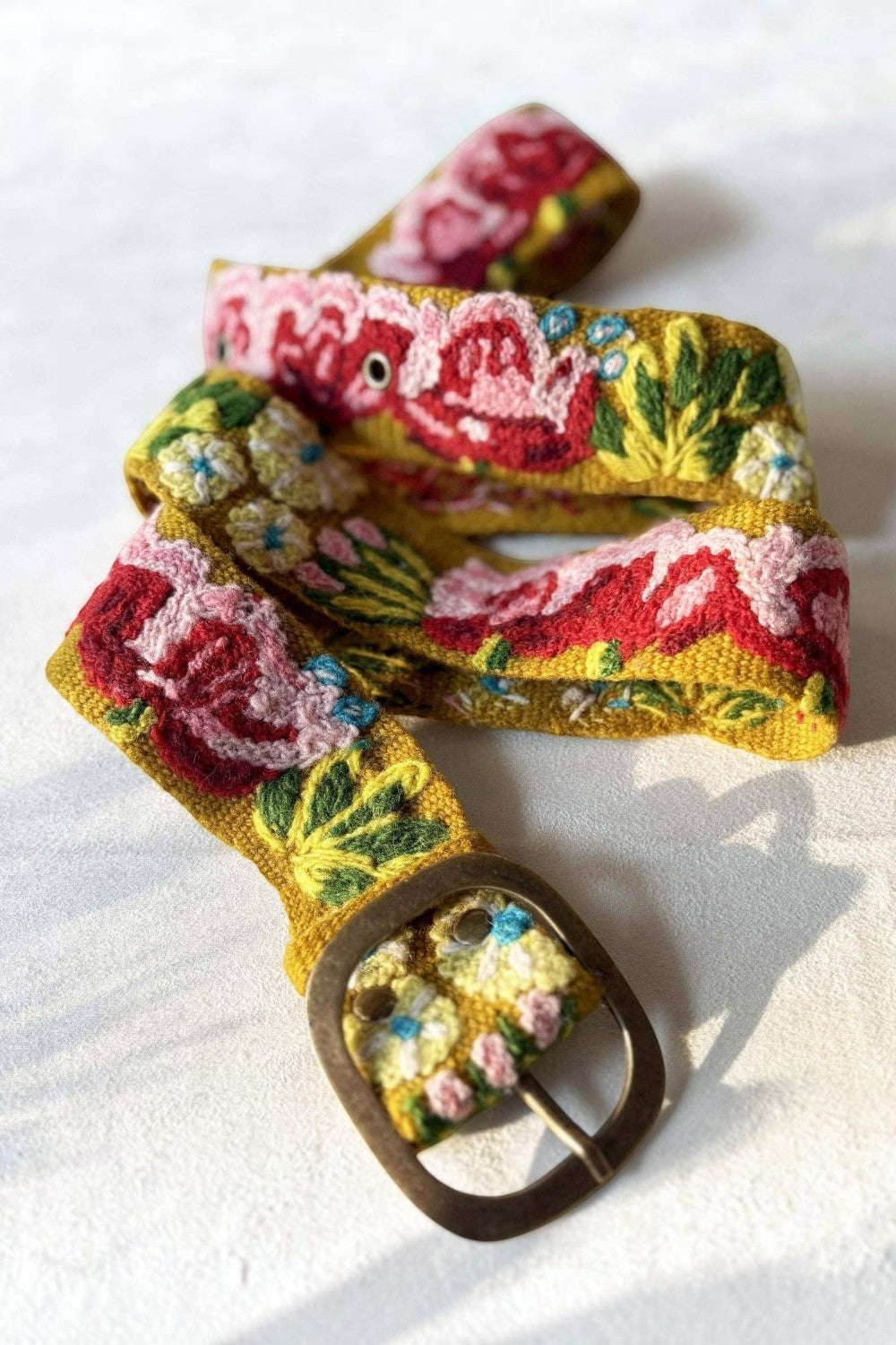 ELSHAM BOUTIQUE Giverny mustard yellow wool belt featuring vibrant floral embroidery and a lead-free metal buckle.