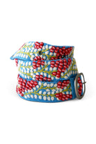 ELSHAM BOUTIQUE wool belt featuring blue fabric with red and white embroidered berry vine patterns and metal buckle.