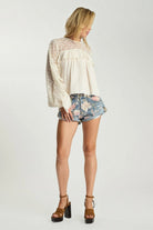 ELSHAM BOUTIQUE low waist denim shorts in floral bloom cobaine blue with patch pockets and rolled hem on a model