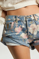 ELSHAM BOUTIQUE low waist denim shorts in Cobaine Blue with pink floral print, rolled hem, and distressed details.