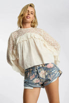 ELSHAM BOUTIQUE low waist denim shorts in floral bloom cobaine blue with patch pockets and rolled hem on a model