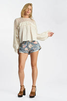 Model wearing ELSHAM BOUTIQUE floral print low waist denim shorts with rolled hems and oversized patch pockets.