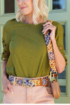 ELSHAM BOUTIQUE wool belt with blue and orange floral embroidery worn at the waist with a matching bag strap