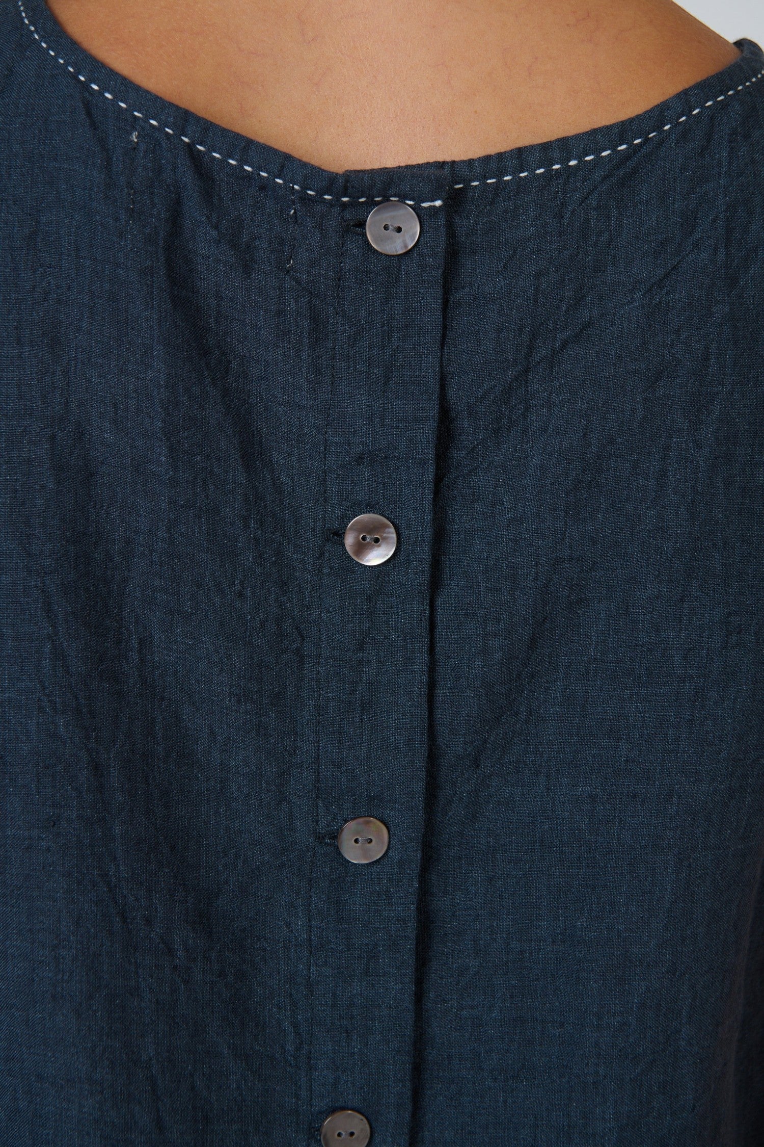 ELSHAM BOUTIQUE sleeveless linen top in gunsmoke grey featuring a round neckline and back button closure detail.