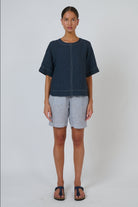Model wearing ELSHAM BOUTIQUE GA724A Neat Top in gunsmoke linen with contrast white topstitching and short sleeves.
