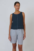 ELSHAM BOUTIQUE sleeveless linen top in gunsmoke grey with white contrast stitching and a relaxed fit on a model.