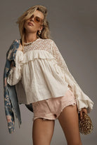 ELSHAM BOUTIQUE ivory cotton blouse with lace yoke, frill details, and long sleeves worn with denim shorts