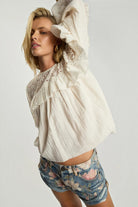 ELSHAM BOUTIQUE ivory cotton blouse with lace inserts, frill detailing, and long sleeves worn by a model