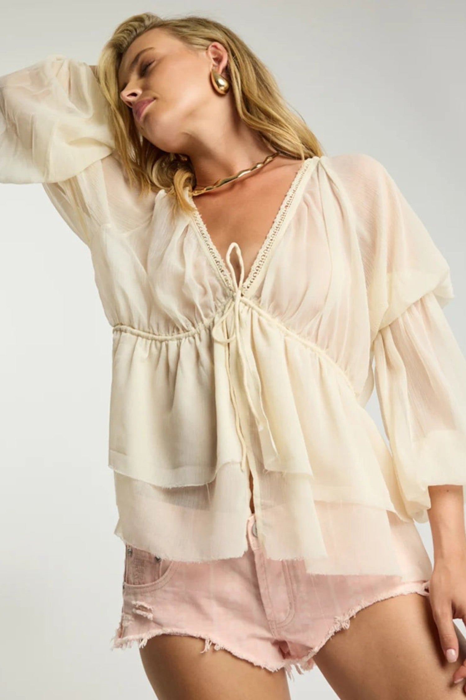 ELSHAM BOUTIQUE ivory sheer chiffon blouse with deep V-neck, lace trim, and voluminous peasant sleeves on a model.
