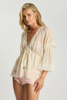 ELSHAM BOUTIQUE ivory sheer chiffon blouse with deep V-neck, lace trim, and voluminous peasant sleeves on a model.