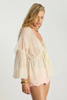 Model wearing ELSHAM BOUTIQUE ivory sheer chiffon blouse with peasant sleeves, V-neck, and lace trim detail.