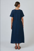 Back view of a woman wearing an ELSHAM BOUTIQUE navy blue 100% linen midi dress with short sleeves and A-line cut.