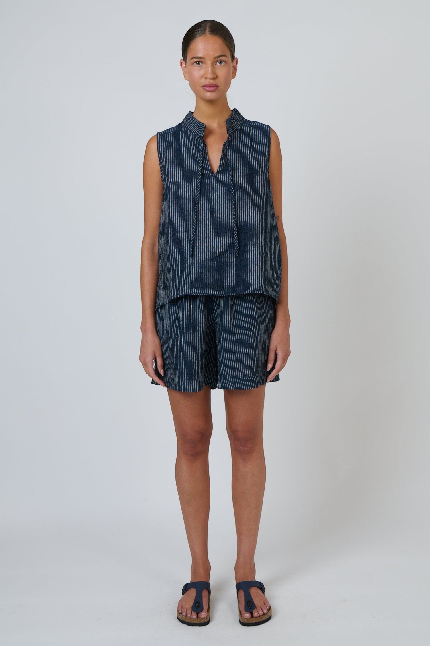 ELSHAM BOUTIQUE GA477 navy pinstripe linen shorts with a drawstring waistband worn by a model in a relaxed fit.