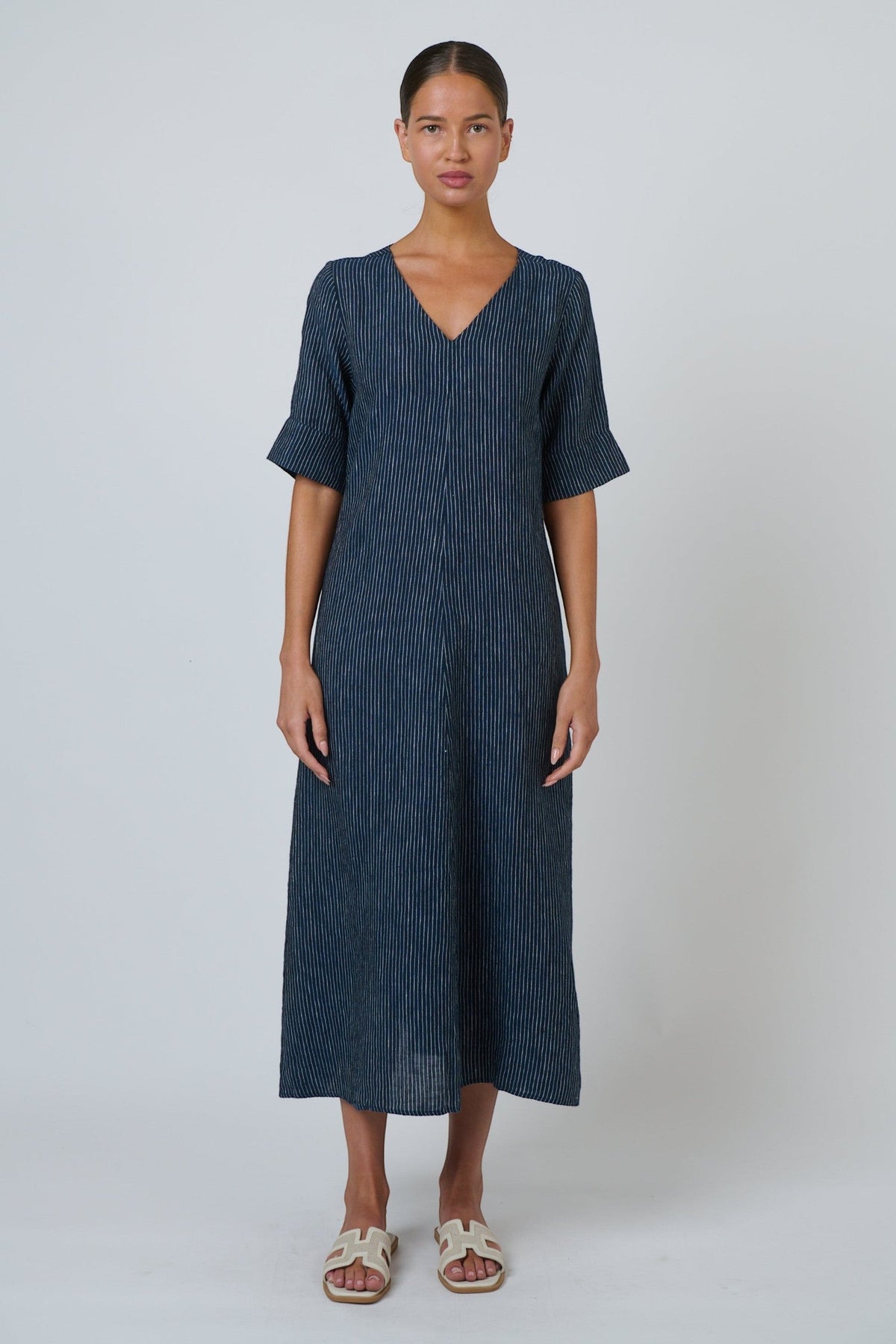 ELSHAM BOUTIQUE navy pinstripe linen midi dress with V-neckline and elbow-length sleeves on a model