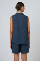 Back view of ELSHAM BOUTIQUE navy pinstripe linen sleeveless top with a high collar on a model.