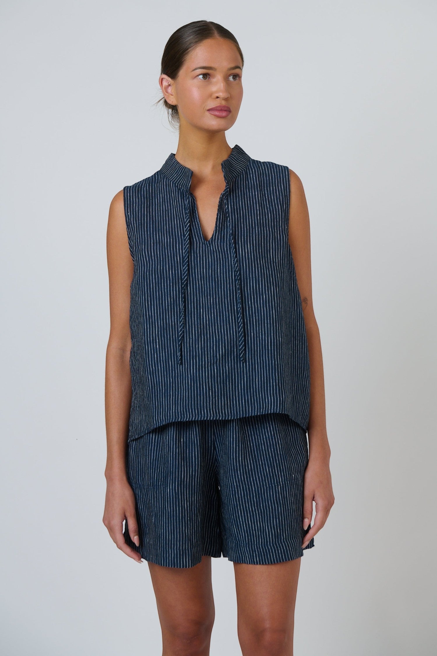 ELSHAM BOUTIQUE navy blue pinstripe linen sleeveless top with a V-neckline and adjustable neck tie detail.