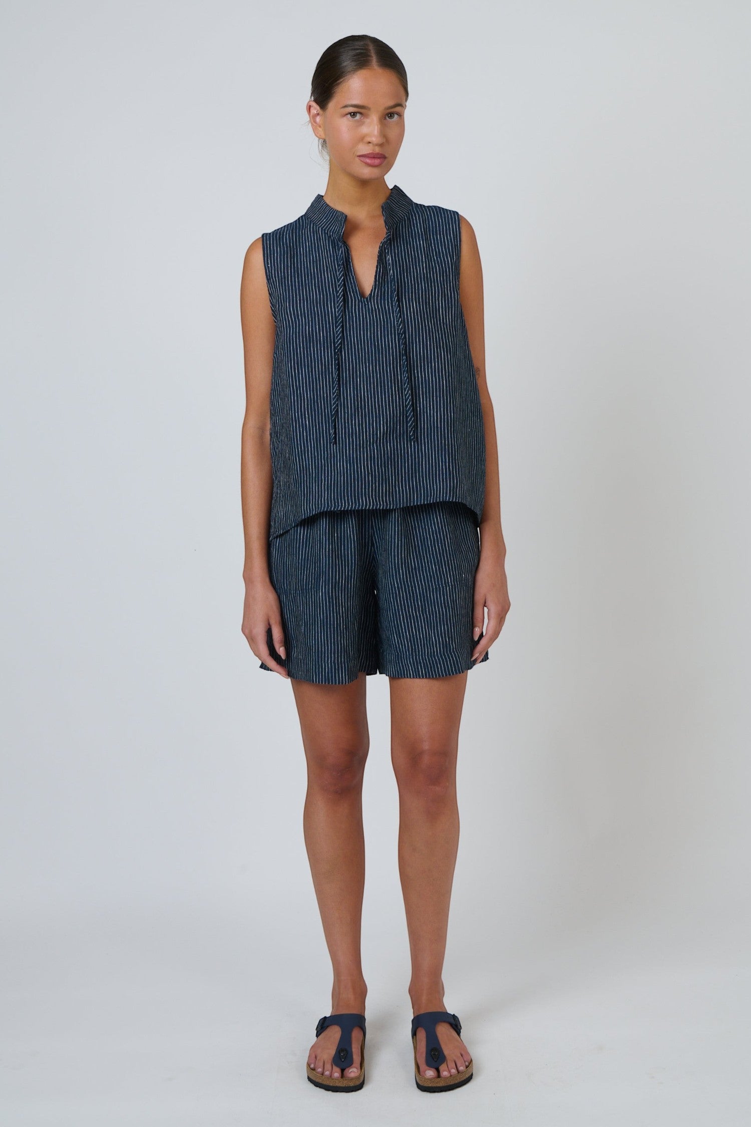 ELSHAM BOUTIQUE navy pinstripe linen sleeveless top with V-neck and drawstring tie worn with matching shorts