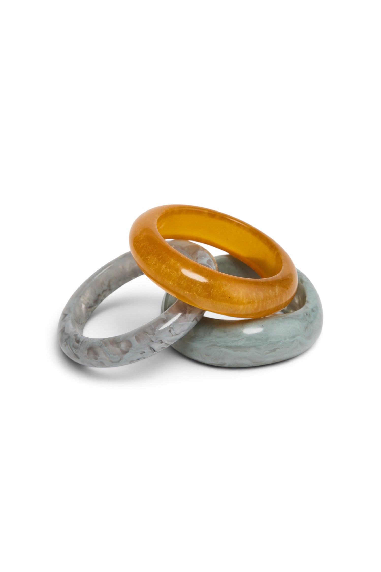 ELSHAM BOUTIQUE Norma bangle set of three glossy resin bracelets in amber, grey, and marbled blue tones.