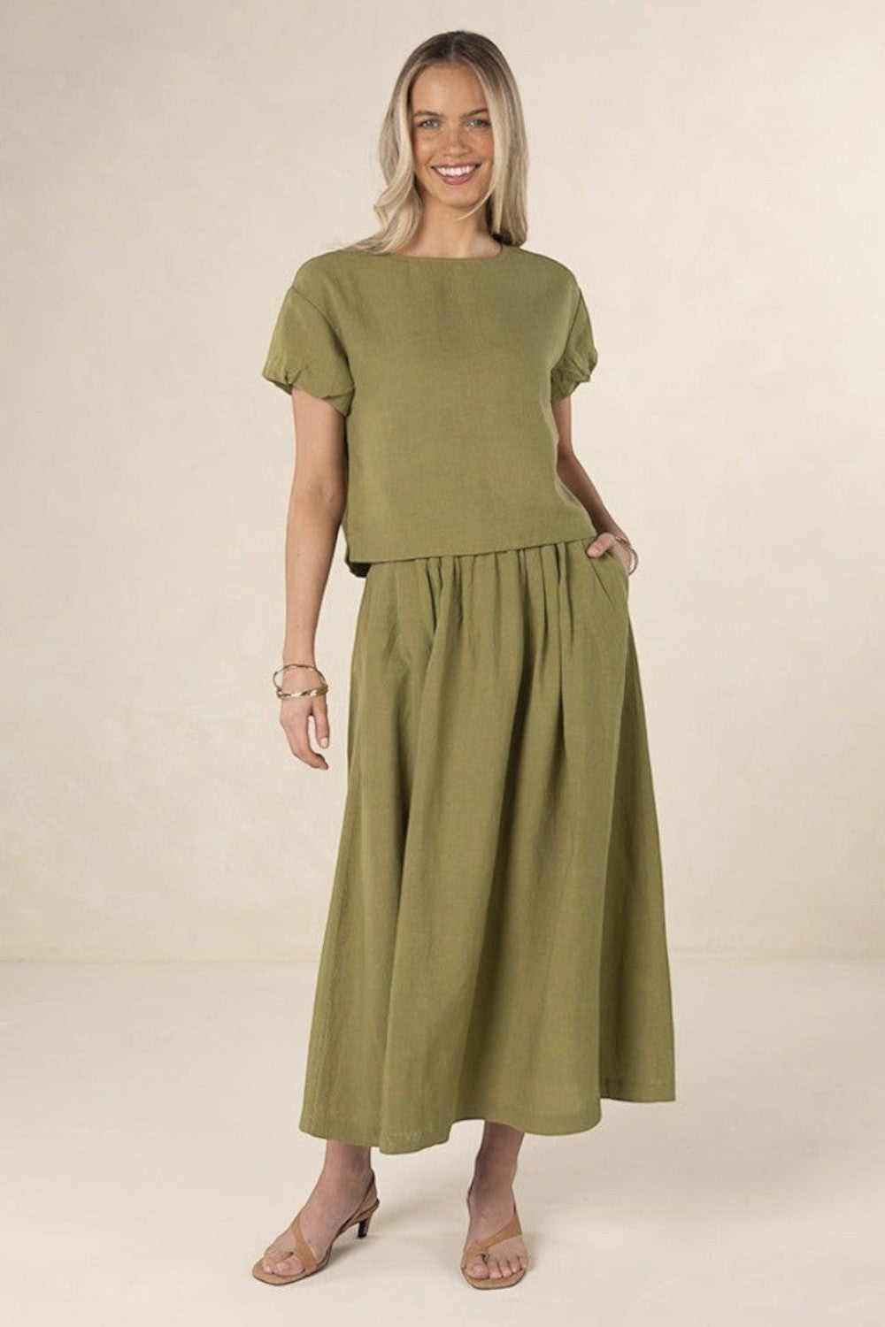 Model wearing ELSHAM BOUTIQUE olive green linen-tencel midi skirt with A-line silhouette and side pockets