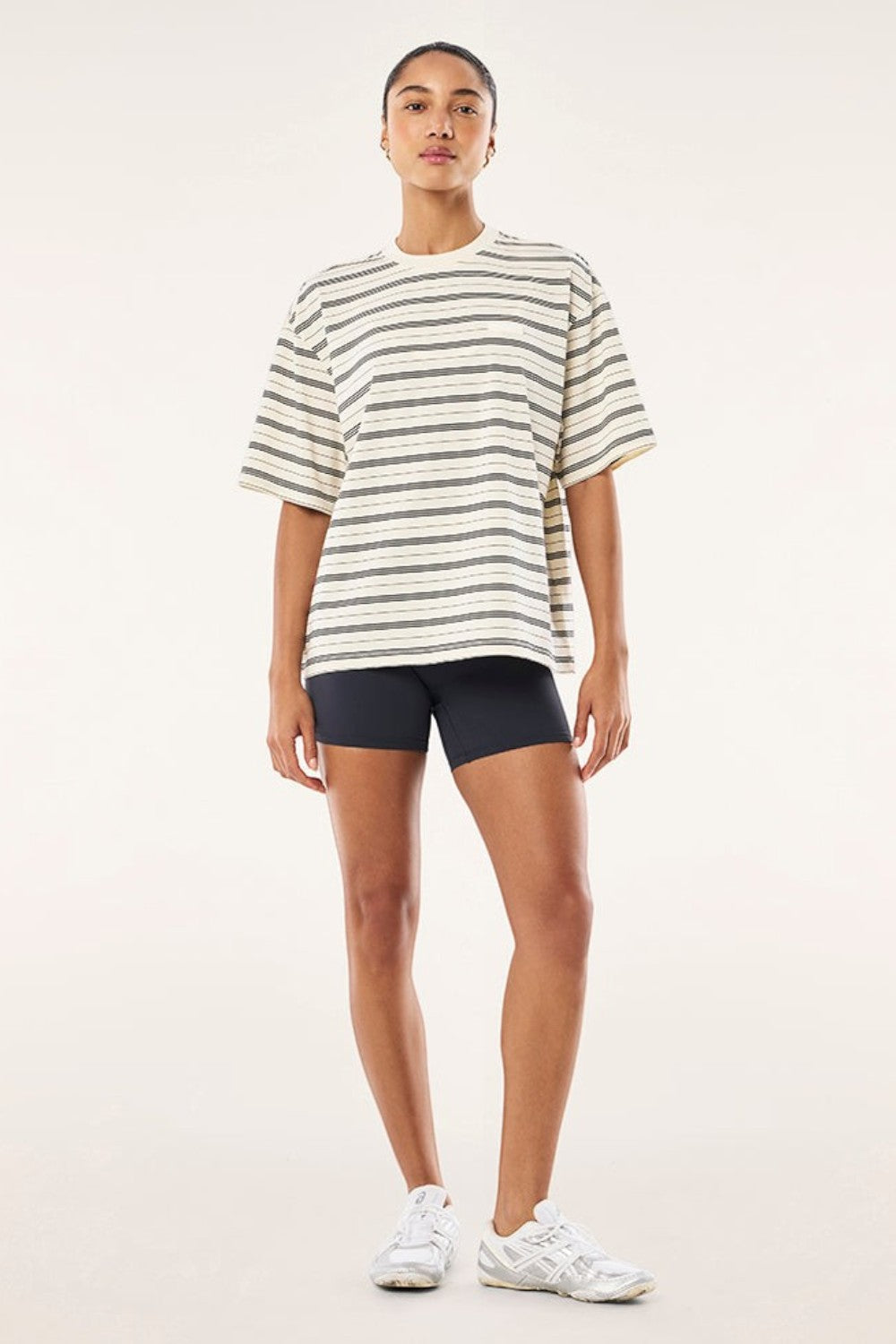 Model wearing ELSHAM BOUTIQUE oversized whisper white striped t-shirt with black shorts and white sneakers