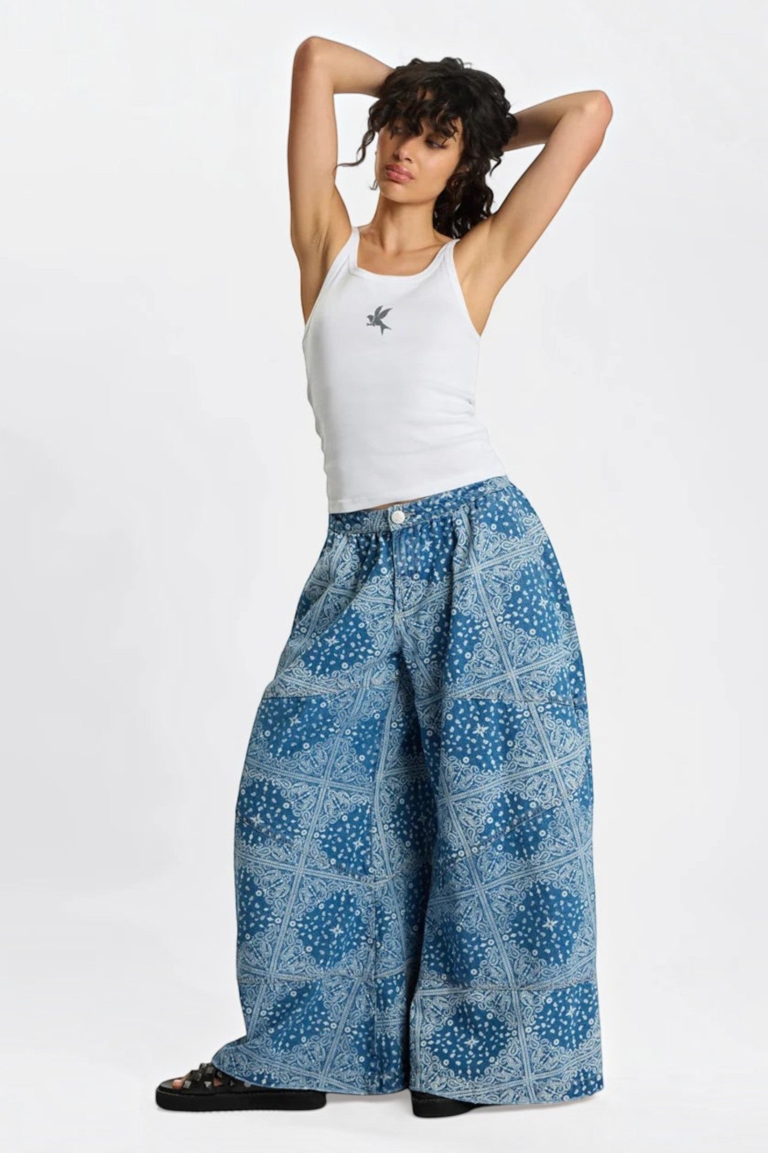 Model wearing ELSHAM BOUTIQUE Daddios low waist super wide leg denim jeans in Aegean paisley blue with asymmetrical seams